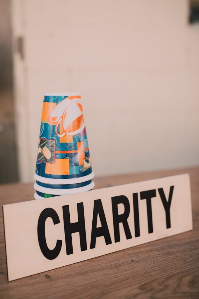 Mastering the First Impression: Your intriguing post title goes here Stacked paper cups and a charity sign symbolizing donations and giving back.